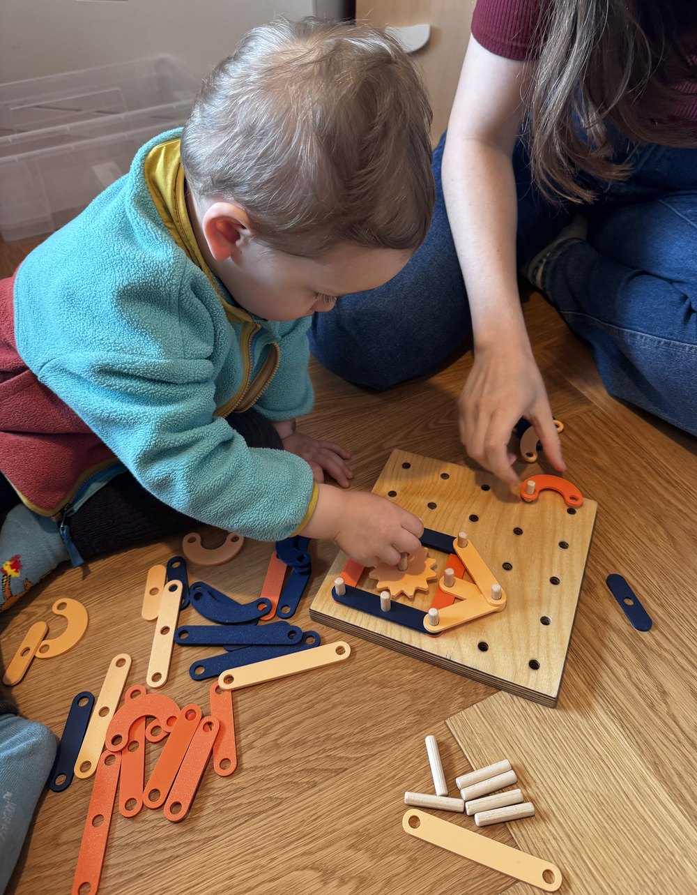 Oli playing with the finished colorful pegboard toy